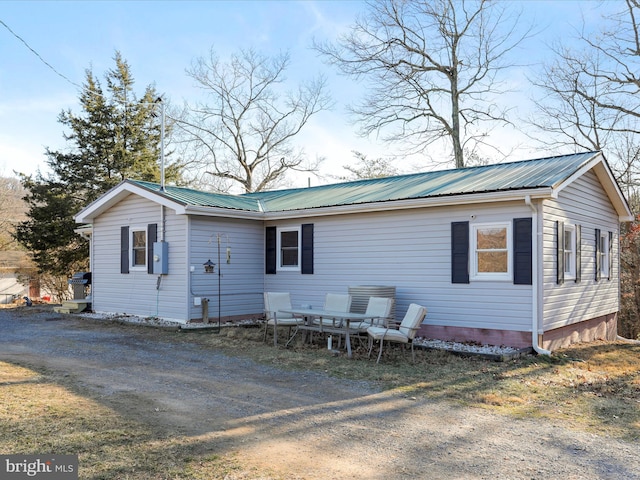 view of front of house featuring metal roof and dirt driveway