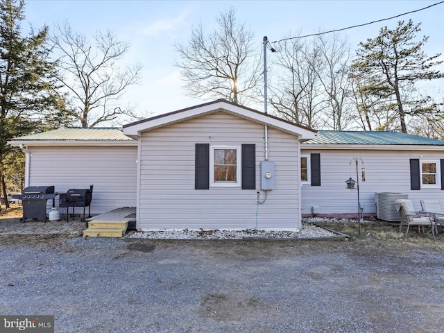 exterior space featuring central air condition unit, metal roof, and a wooden deck