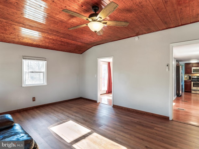 empty room with vaulted ceiling, wood finished floors, wood ceiling, and baseboards