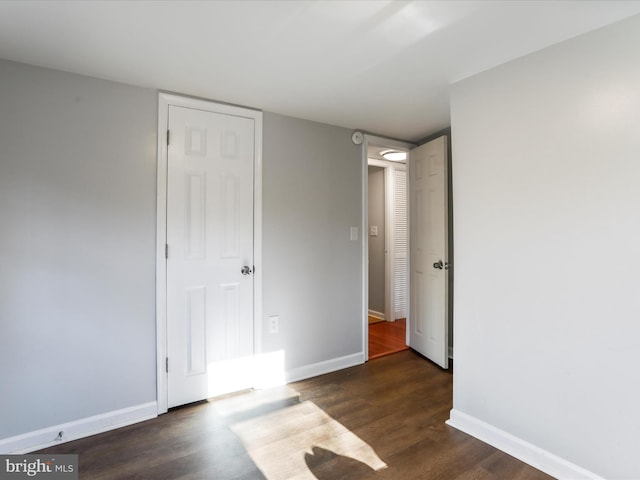 unfurnished bedroom featuring baseboards and wood finished floors