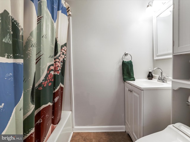 bathroom featuring baseboards, toilet, vanity, and tile patterned floors