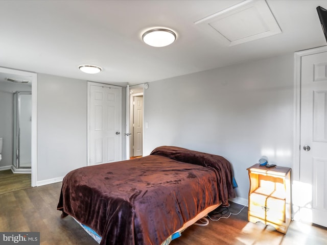 bedroom featuring wood finished floors, attic access, and baseboards