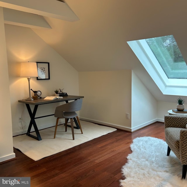 office featuring vaulted ceiling with skylight, baseboards, and wood finished floors