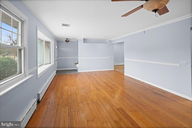 empty room featuring a baseboard heating unit, light wood-type flooring, crown molding, and a baseboard radiator