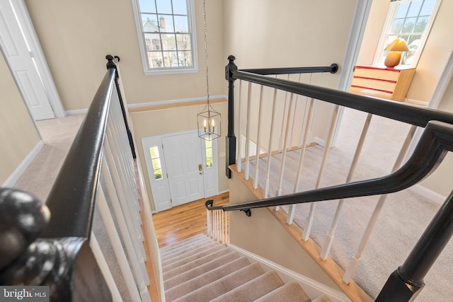 staircase featuring baseboards and wood finished floors