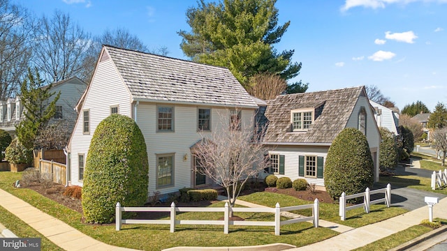 colonial home with a front lawn and fence