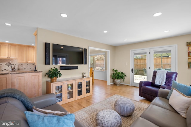 living area with recessed lighting, baseboards, and light wood finished floors