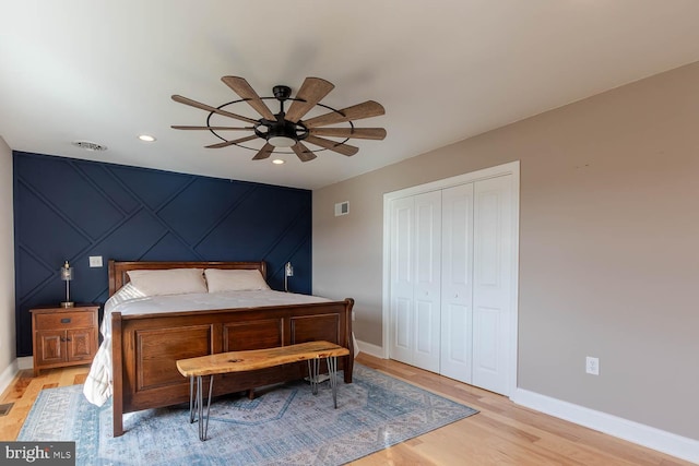 bedroom featuring light wood finished floors, a closet, visible vents, and baseboards