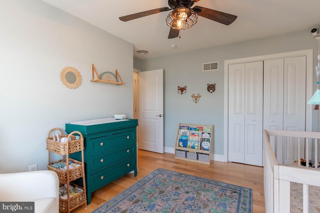 bedroom with a closet, visible vents, light wood-style floors, a ceiling fan, and baseboards