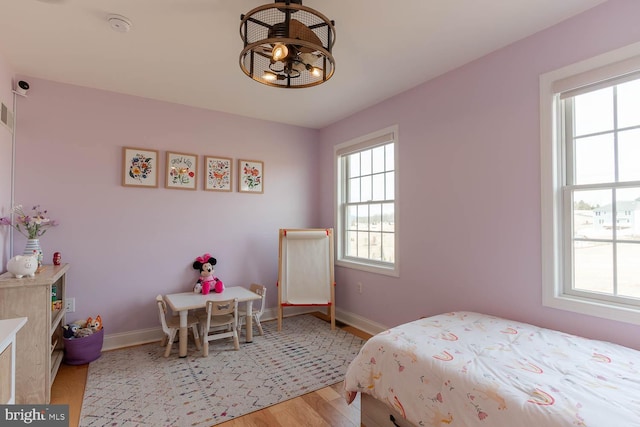 bedroom featuring light wood finished floors and baseboards