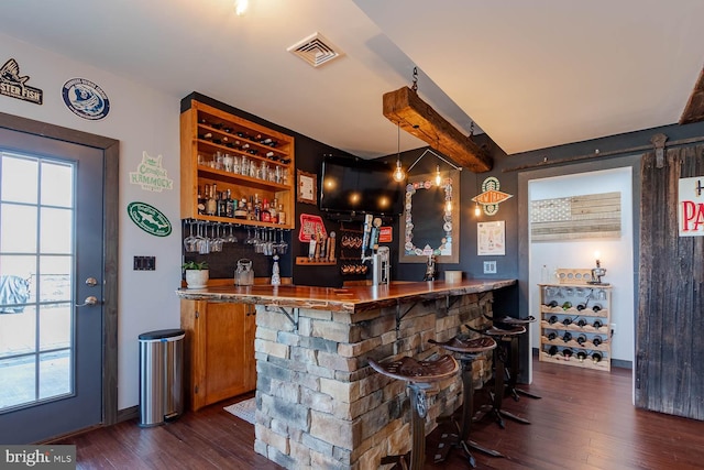 bar with a bar, plenty of natural light, visible vents, and dark wood finished floors