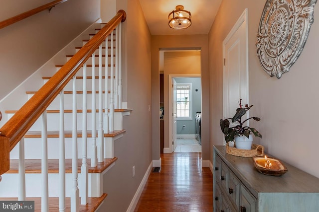 hallway with stairs, baseboards, and wood finished floors