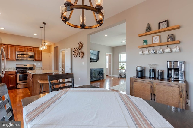 dining room featuring a chandelier, recessed lighting, baseboards, and wood finished floors