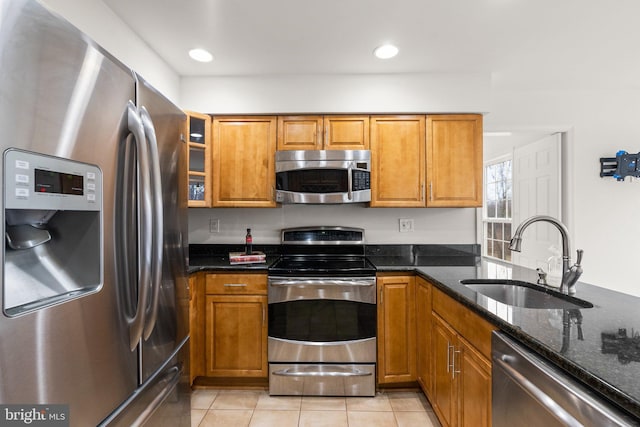 kitchen featuring stainless steel appliances, a sink, and brown cabinets