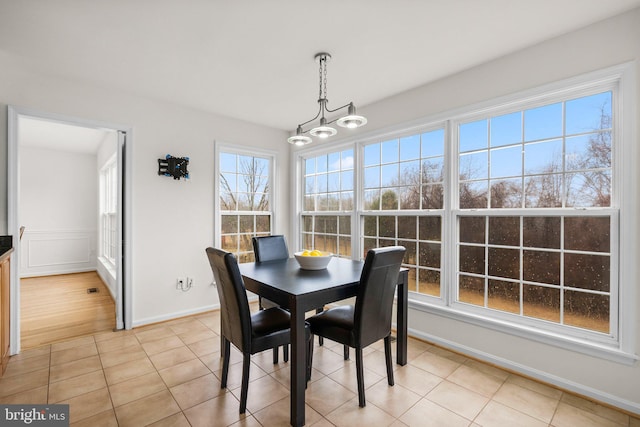 dining room with baseboards, a chandelier, and light tile patterned flooring