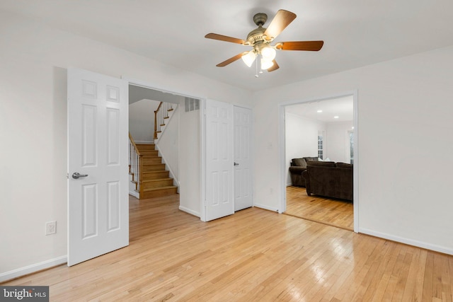 interior space with baseboards, ceiling fan, visible vents, and light wood finished floors