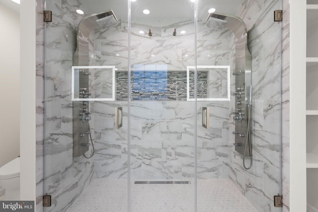 full bath featuring toilet and a marble finish shower