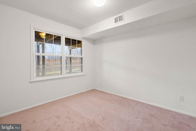 carpeted empty room featuring baseboards and visible vents