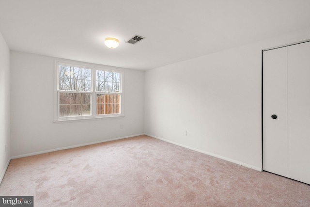 unfurnished bedroom featuring a closet, visible vents, baseboards, and carpet flooring