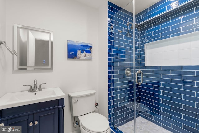 bathroom with a stall shower, vanity, and toilet