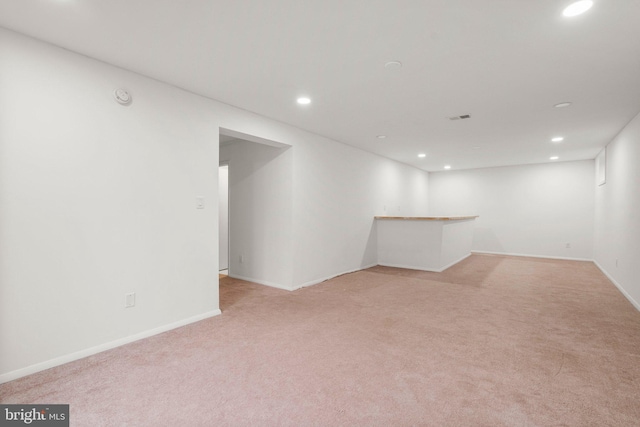 spare room with light carpet, a dry bar, visible vents, and recessed lighting