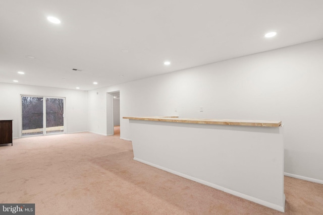 spare room with recessed lighting, light colored carpet, and baseboards