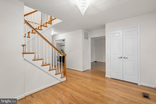 interior space featuring a chandelier, visible vents, baseboards, and wood finished floors