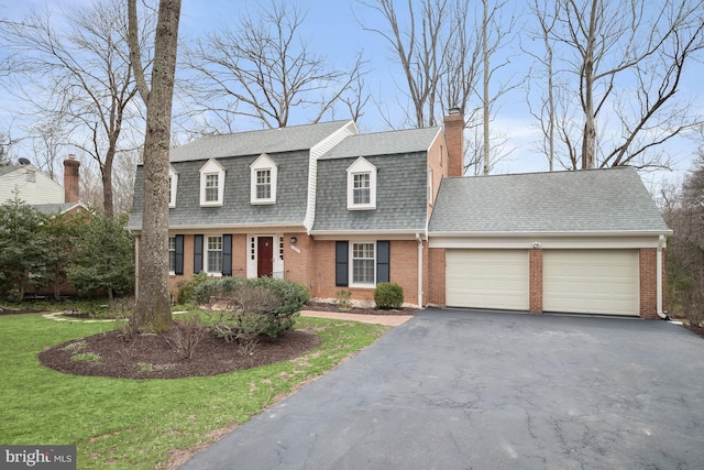 dutch colonial featuring aphalt driveway, brick siding, a shingled roof, a garage, and a front lawn