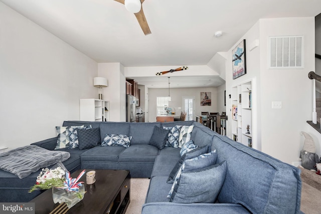 living room featuring ceiling fan and visible vents