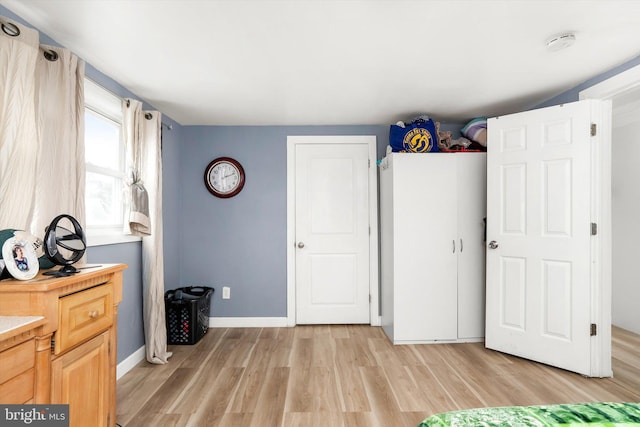 unfurnished bedroom with light wood-style flooring and baseboards