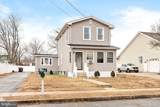 traditional-style home featuring cooling unit, driveway, and fence