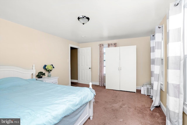 bedroom featuring baseboards and light colored carpet