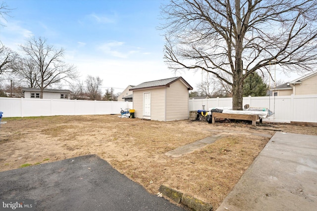 view of yard featuring an outbuilding, a storage unit, and a fenced backyard