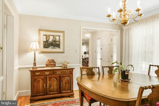 dining room with light wood-type flooring, a chandelier, and ornamental molding