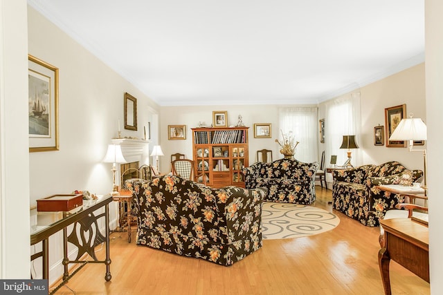 living room featuring crown molding, a fireplace, and wood finished floors