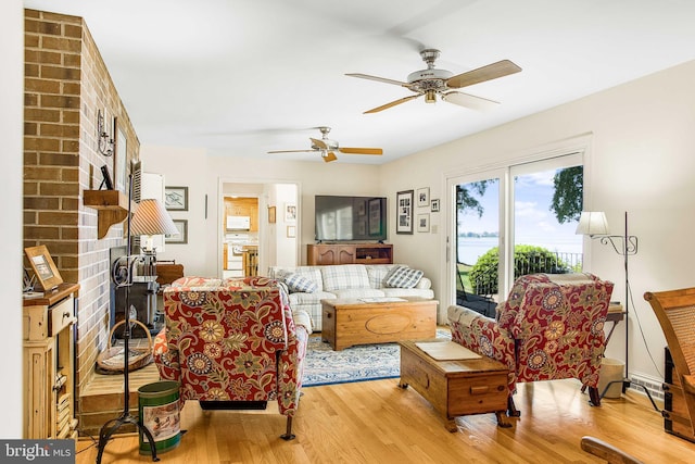 living room featuring light wood-style flooring and a ceiling fan