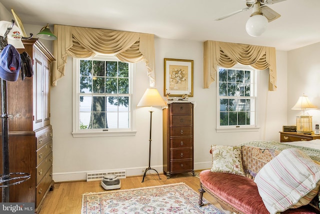 sitting room featuring visible vents, plenty of natural light, baseboards, and wood finished floors