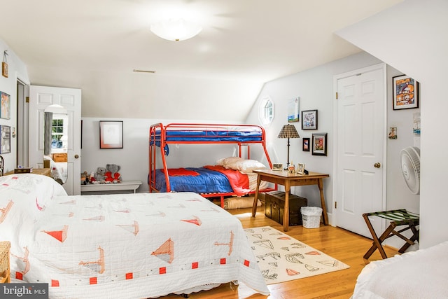 bedroom with vaulted ceiling and wood finished floors