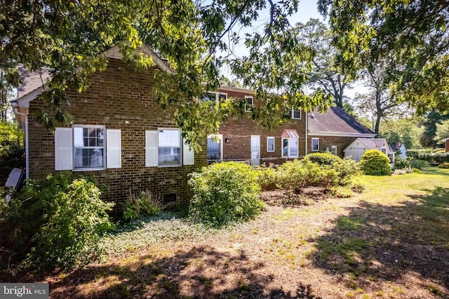 view of front of home featuring crawl space and brick siding