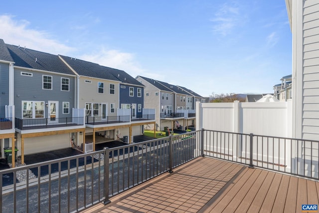 wooden terrace with a residential view, central AC, and an attached garage