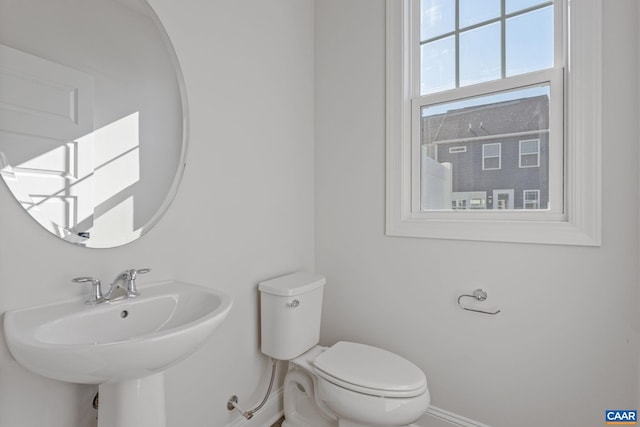 bathroom with a sink, toilet, and baseboards