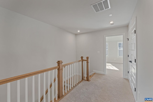 hall with visible vents, baseboards, carpet, an upstairs landing, and recessed lighting