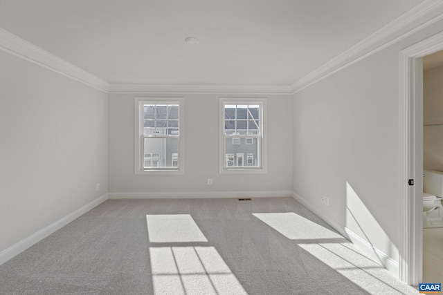 carpeted empty room with ornamental molding and baseboards