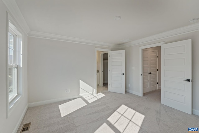 unfurnished bedroom featuring crown molding, visible vents, and light colored carpet