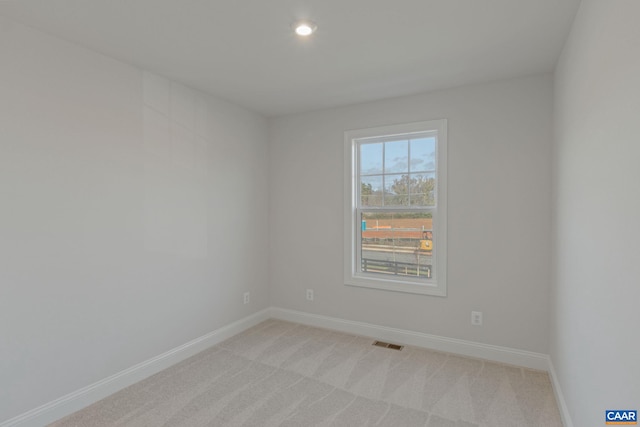 unfurnished room featuring recessed lighting, light colored carpet, visible vents, and baseboards