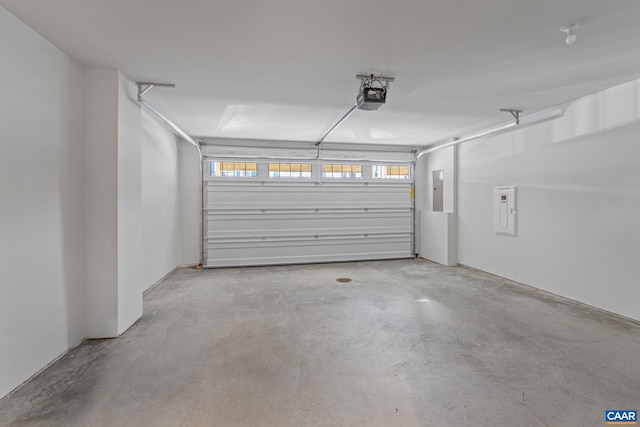 garage with a garage door opener and electric panel