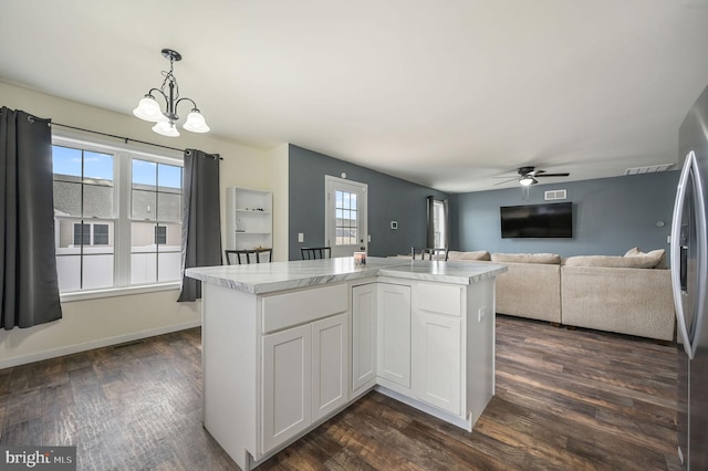 kitchen featuring hanging light fixtures, dark wood-style flooring, light countertops, and a wealth of natural light