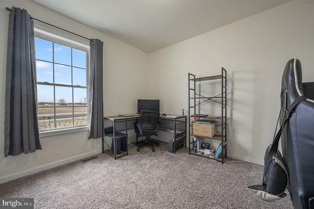 office area with carpet floors, visible vents, plenty of natural light, and baseboards