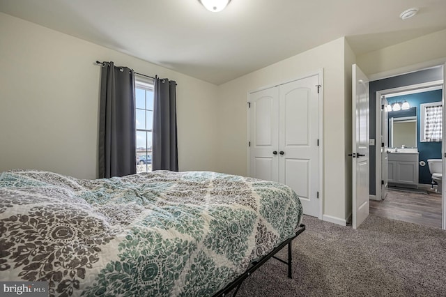 carpeted bedroom with a closet, a sink, and baseboards