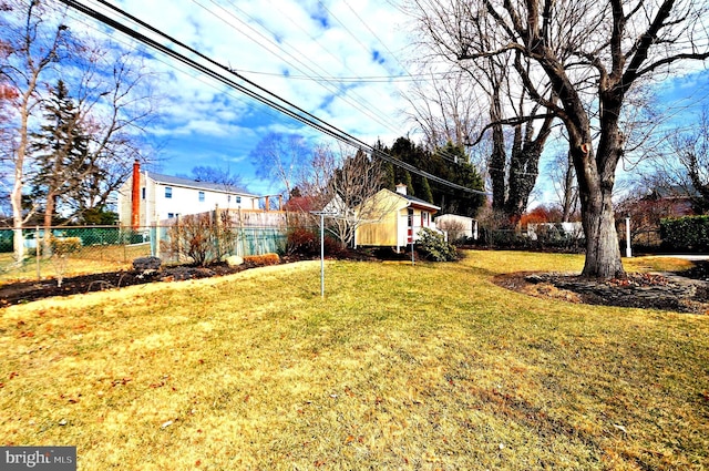 view of yard with fence and an outdoor structure